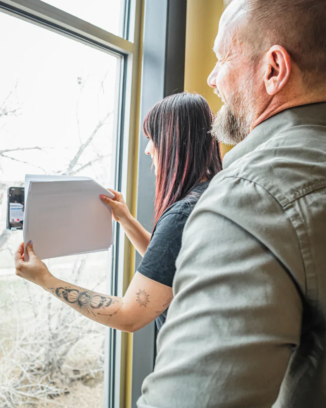 Brillity Digital teammates reviewing printed reports by the office window